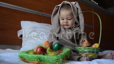 可爱的宝宝穿着兔子服装玩复活节彩蛋。 关门